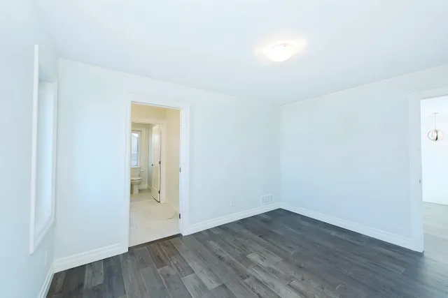 Bedroom with grey plank flooring and a window