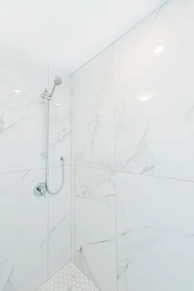 Marble-look porcelain shower wall with the fixtures