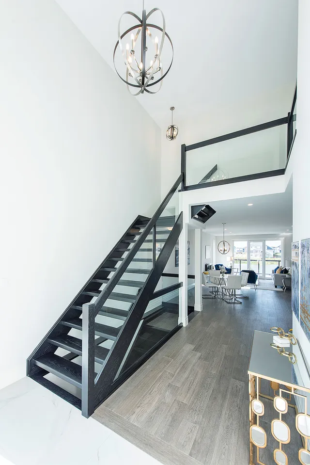 Black steel stair with a glass balustrade over the porcelain floor of the lakeside house