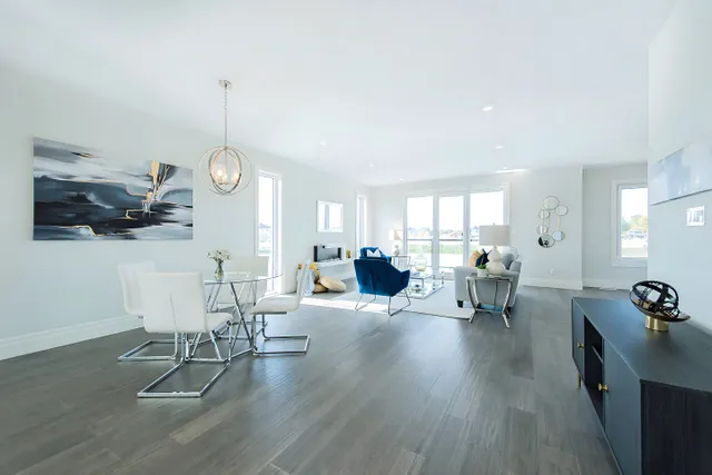 Dining area with grey plank flooring and a pendant