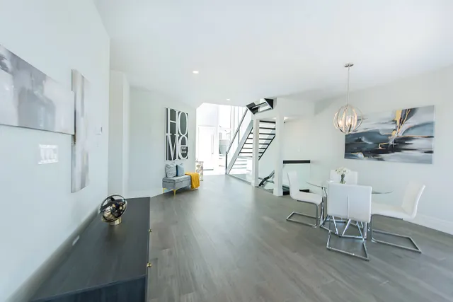 Great room with grey plank, the dining table and the black steel stair