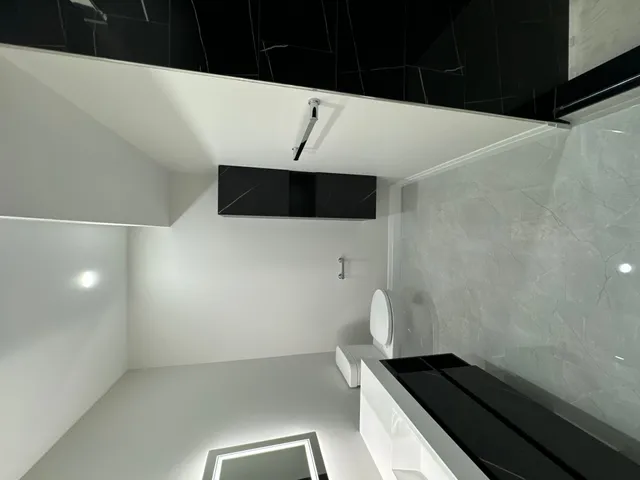 Ensuite in white porcelain with a black band and the bath surround