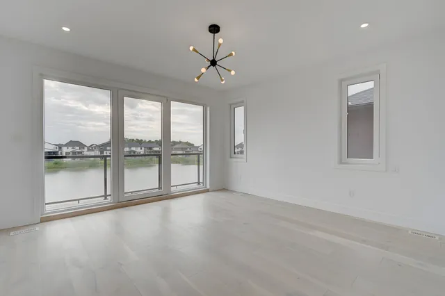 Great room with grey plank flooring and windows to the water