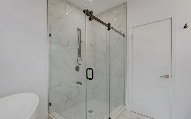 Shower in marble-look porcelain with a glass door